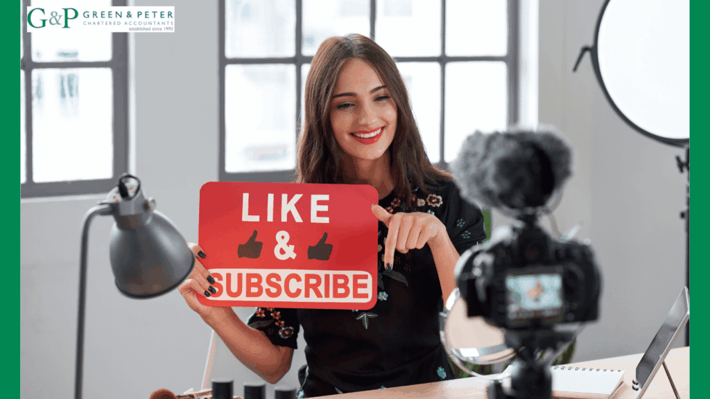 do uk youtubers pay tax? uk youtuber holding a red sign which says like & subscribe