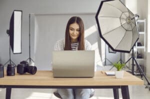photographer working on laptop in studio with camera equipment, representing photography tax deductions in london.