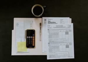 tax documents, calculator and financial paperwork on a desk representing a financial guide for artists in the uk.